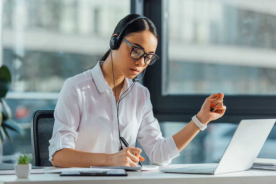 Beautiful Asian Translator Working Online With Headset And Lapto